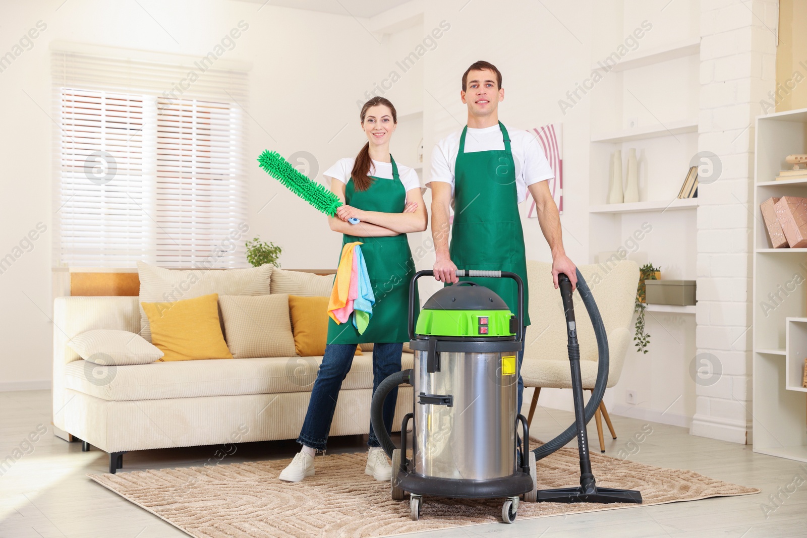 Photo of Cleaning service workers with equipment in room