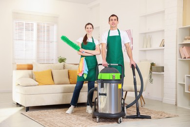 Cleaning service workers with equipment in room