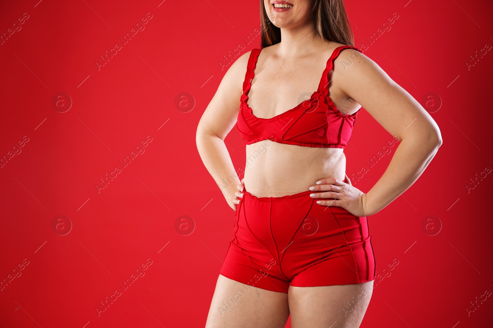 Photo of Woman in underwear on red background, closeup. Cellulite problem