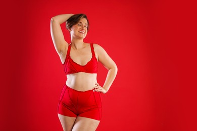 Woman in underwear on red background, space for text. Cellulite problem