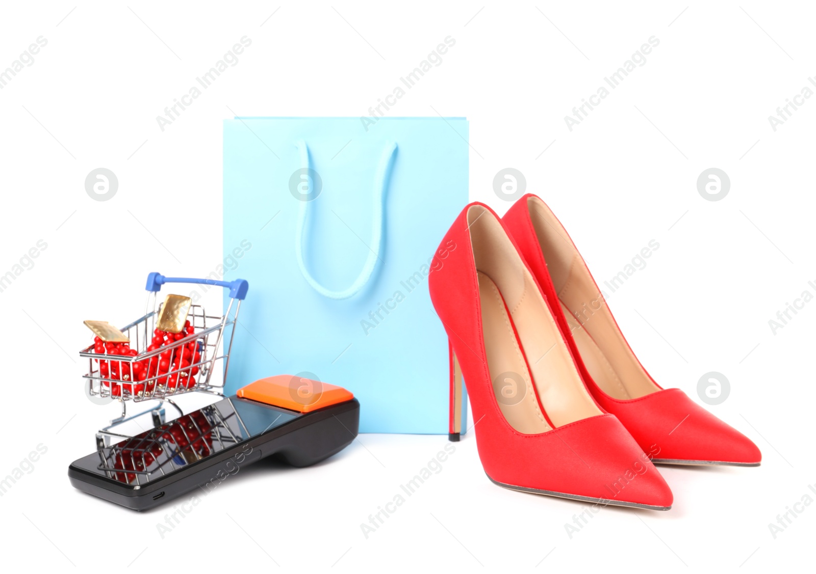 Photo of Payment terminal, heels, shopping bag and mini cart with earrings isolated on white