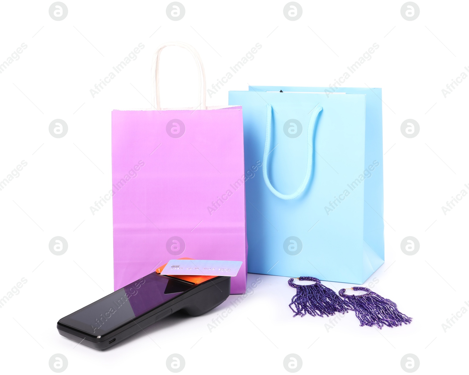 Photo of Payment terminal, shopping bags and earrings isolated on white