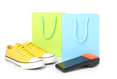 Photo of Payment terminal, shopping bags and sneakers isolated on white