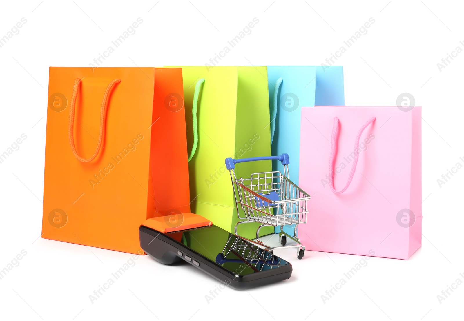 Photo of Payment terminal, shopping bags and mini cart isolated on white