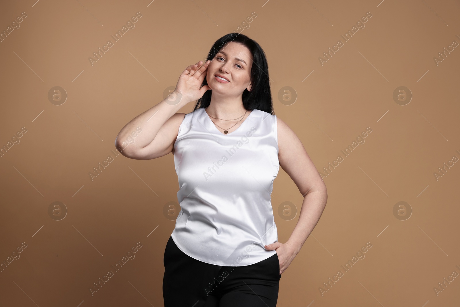 Photo of Portrait of smiling plus size model on beige background. Overweight