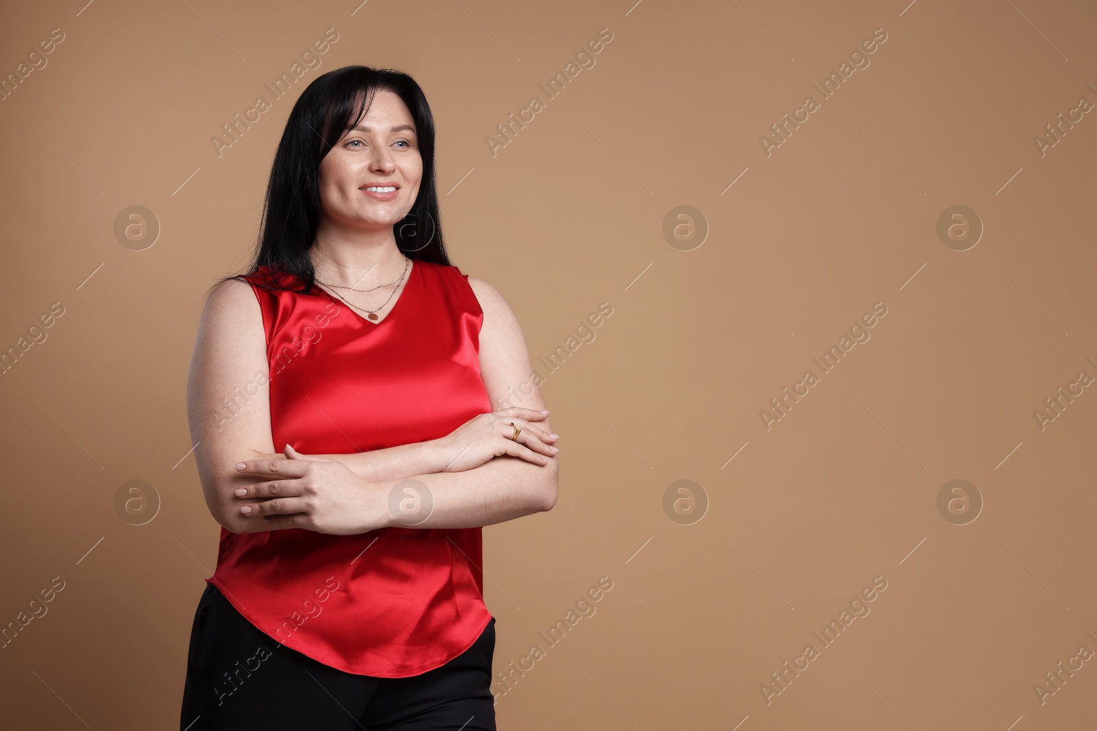 Photo of Portrait of smiling plus size model on beige background, space for text. Overweight