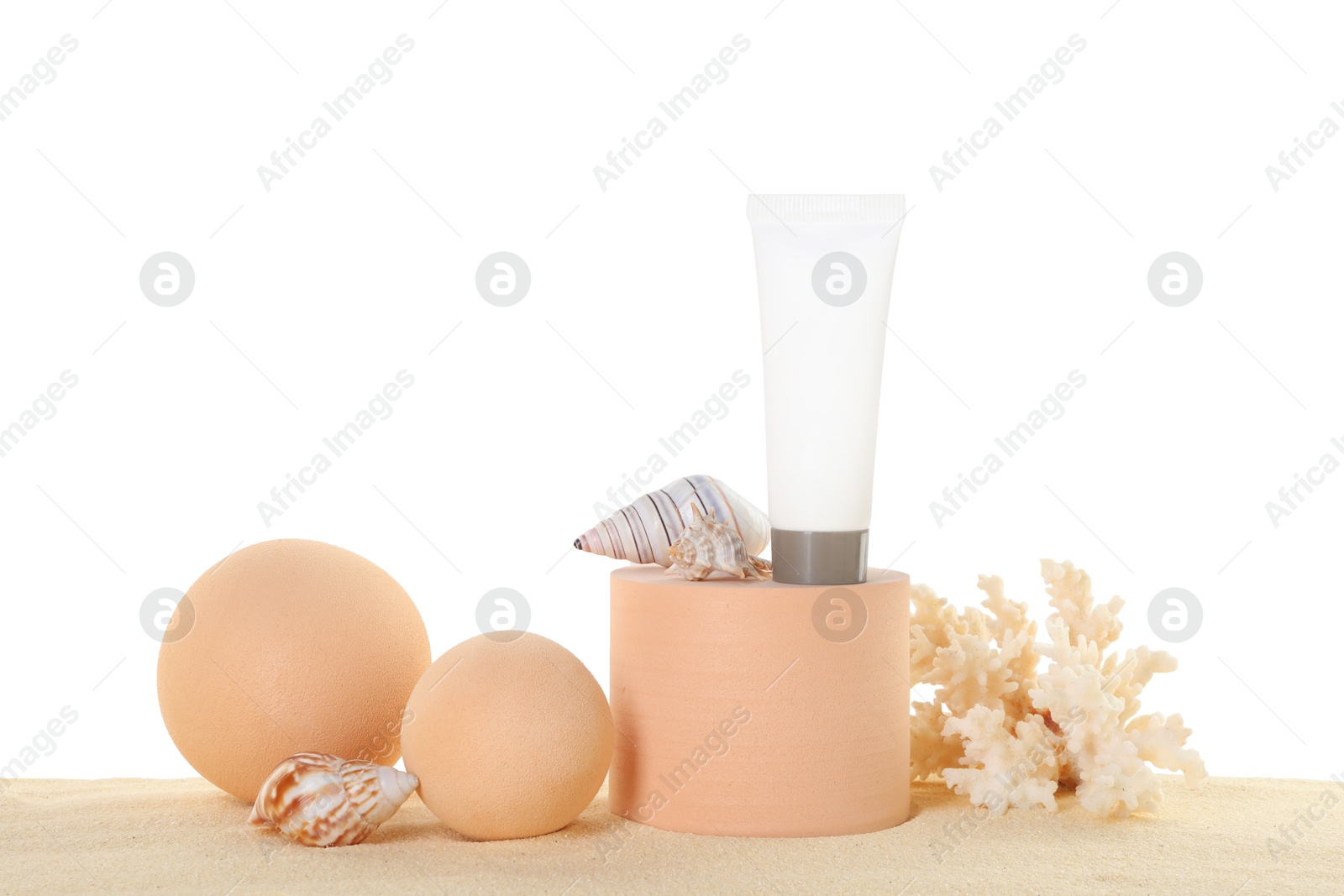 Photo of Tube of sun protection product, coral and seashells on sand against white background