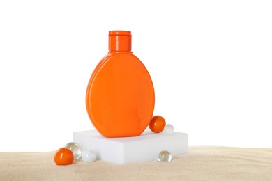 Photo of Bottle of sun protection product and decorative stones on sand against white background