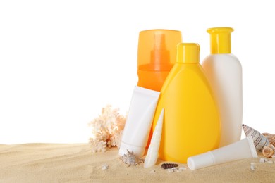 Different sun protection products, coral and seashells on sand against white background