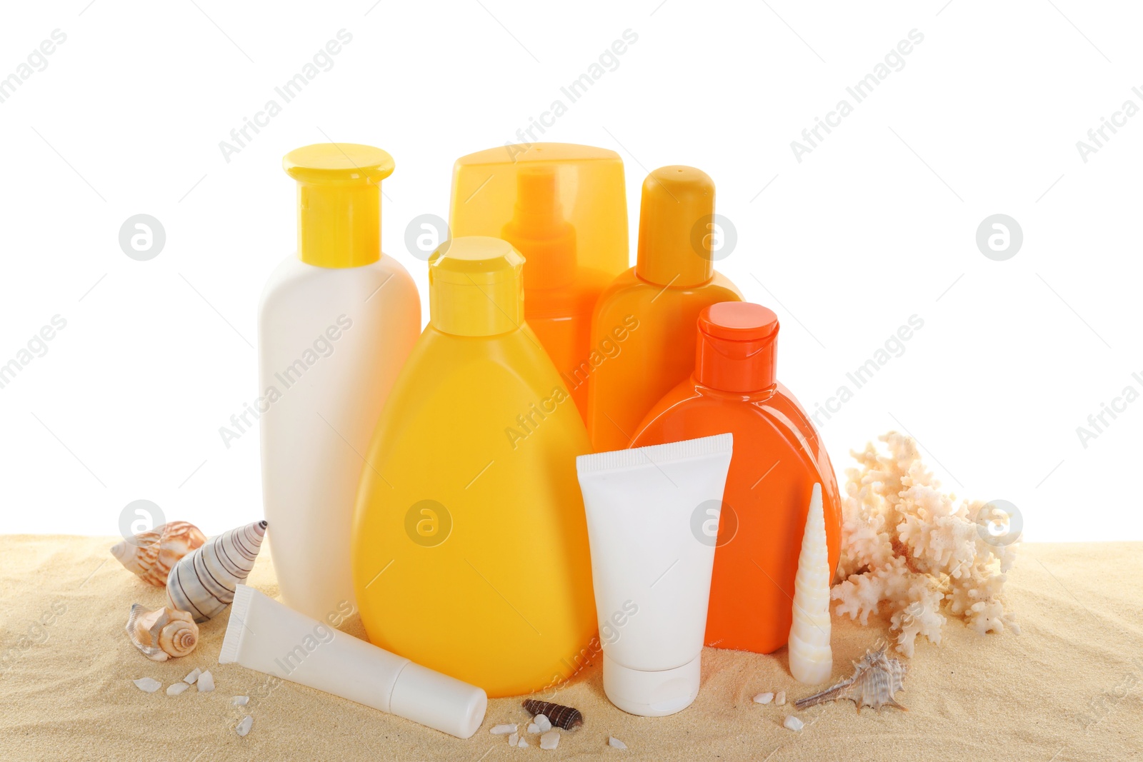 Photo of Different sun protection products, coral and seashells on sand against white background