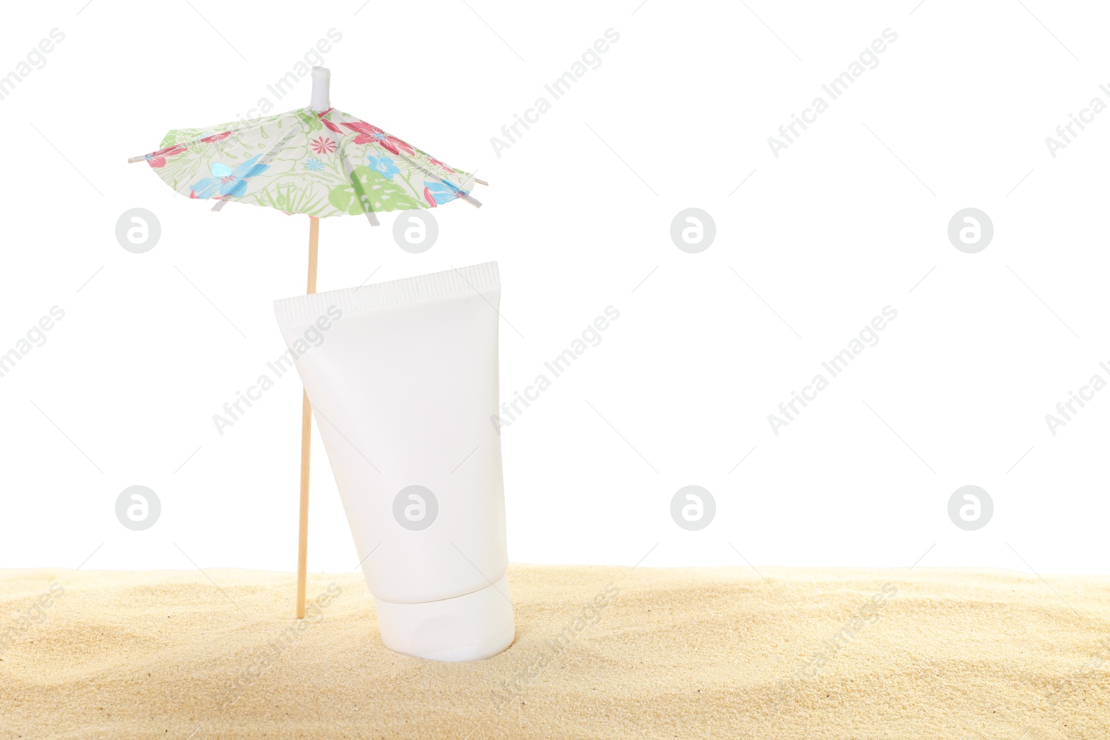 Photo of Tube of sun protection product and small umbrella on sand against white background