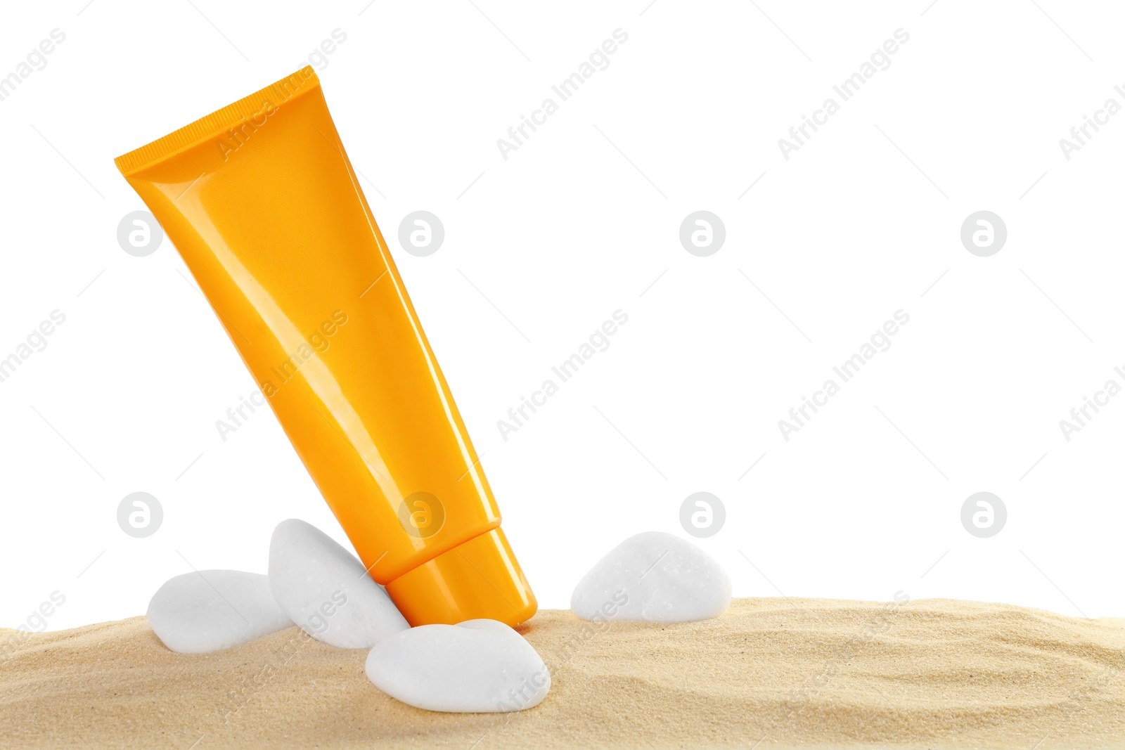 Photo of Tube of sun protection product and stones on sand against white background