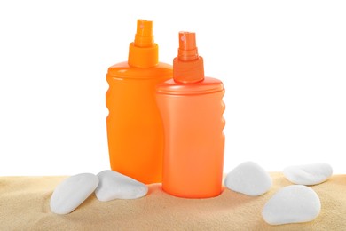 Bottles of sun protection product and stones on sand against white background