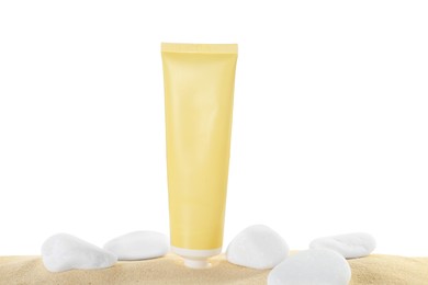 Photo of Tube of sun protection product and stones on sand against white background