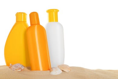 Photo of Different sun protection products and seashells on sand against white background