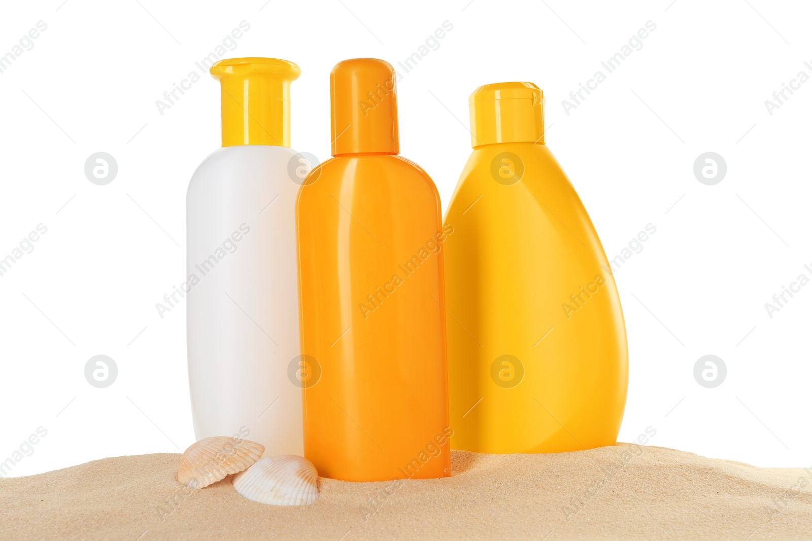 Photo of Different sun protection products and seashells on sand against white background