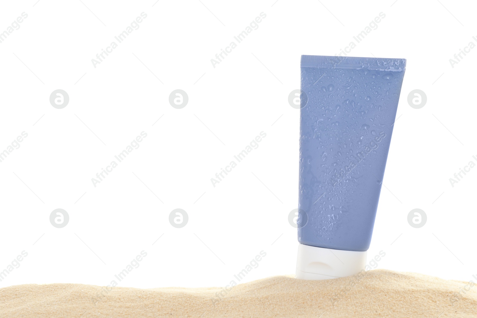 Photo of Tube of sun protection product on sand against white background