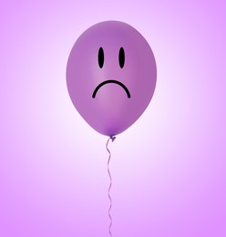 Image of Bright balloon with unhappy face on violet gradient background