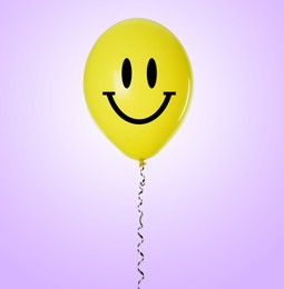 Yellow balloon with happy face on violet gradient background