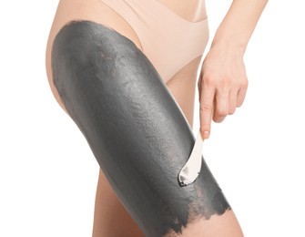 Woman applying cosmetic product for spa body wraps onto her leg against white background, closeup