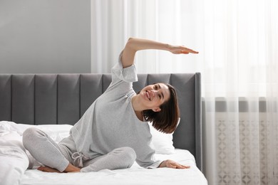 Young woman exercising on bed at home. Morning routine