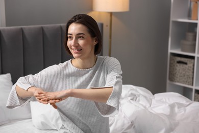 Young woman exercising on bed at home. Morning routine