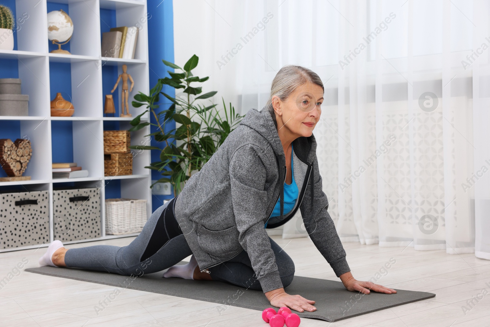 Photo of Elderly woman exercising at home. Healthy leisure