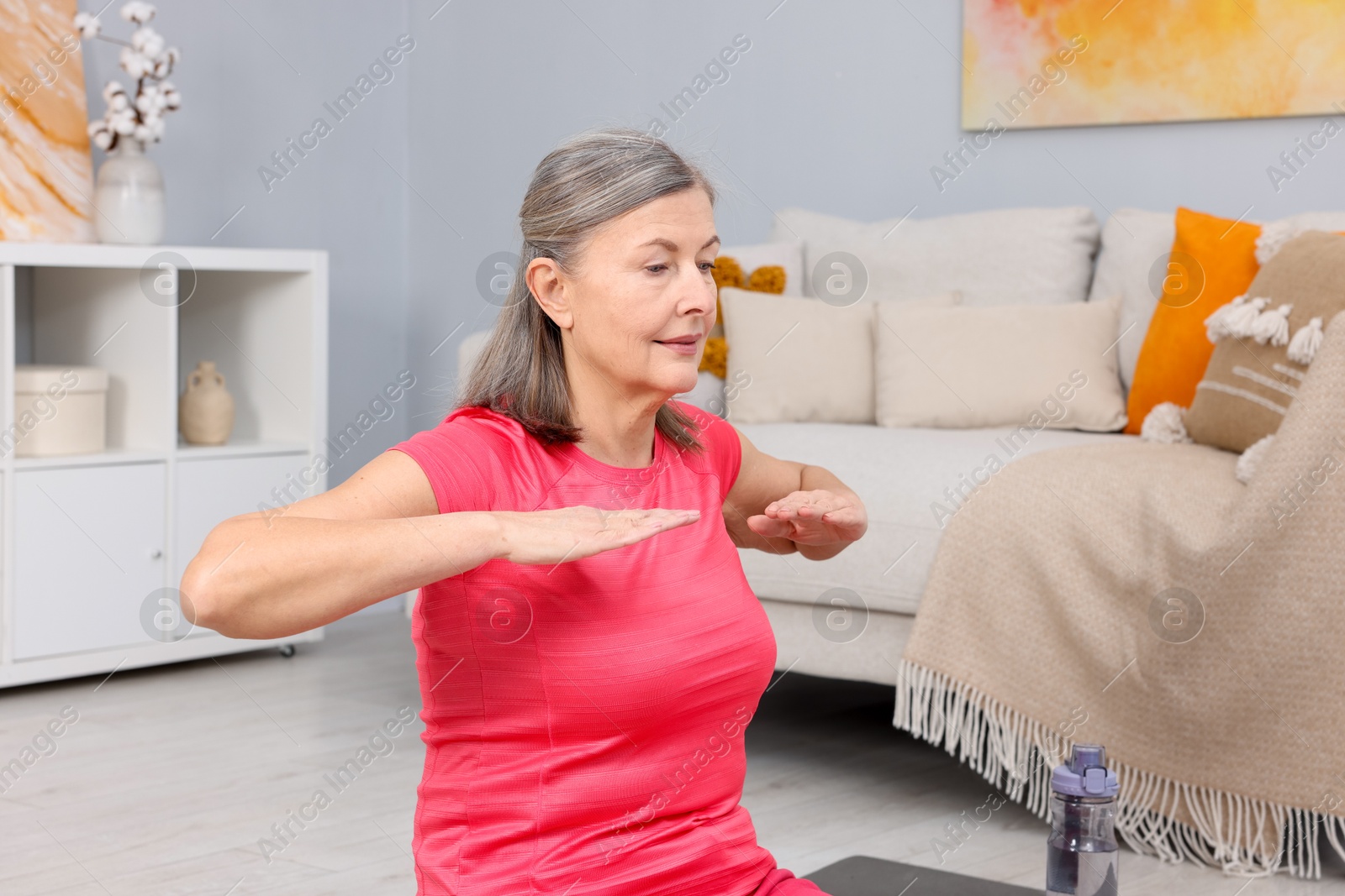 Photo of Elderly woman doing exercise at home. Healthy leisure