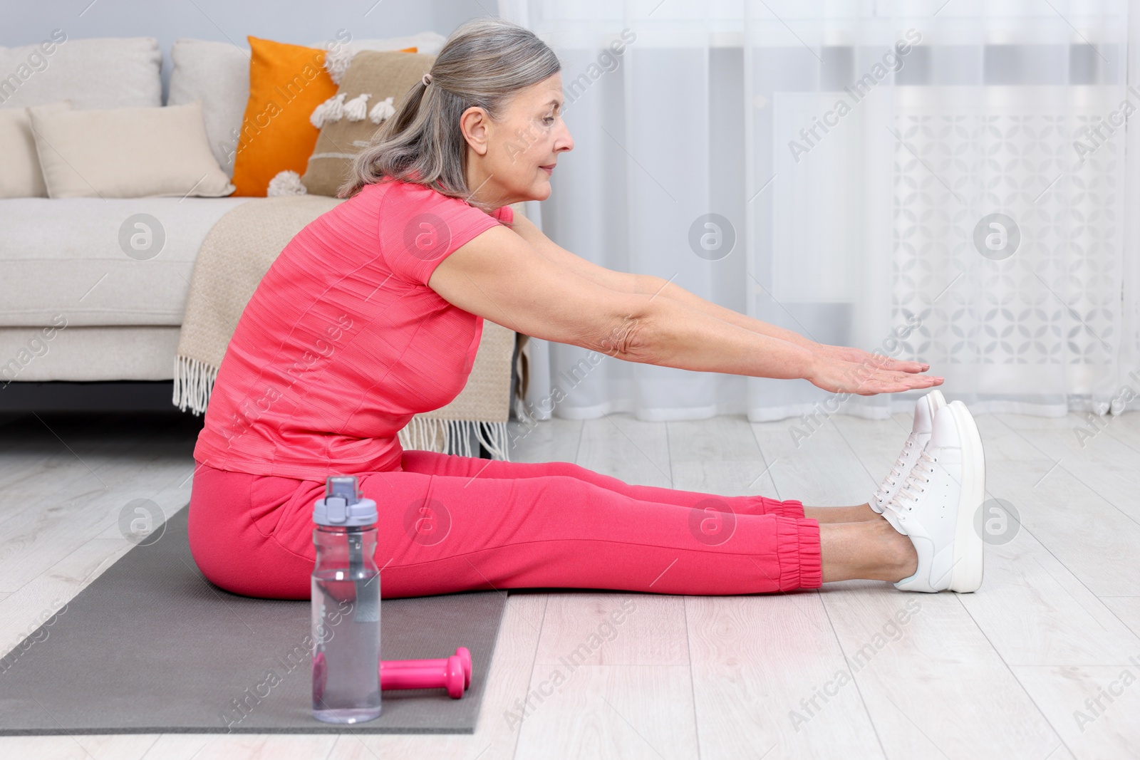 Photo of Elderly woman doing exercise at home. Healthy leisure