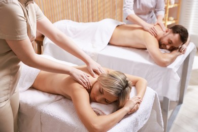 Couple receiving relaxing massage in spa salon, selective focus