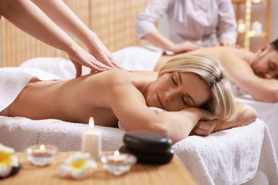 Couple receiving relaxing massage in spa salon, selective focus