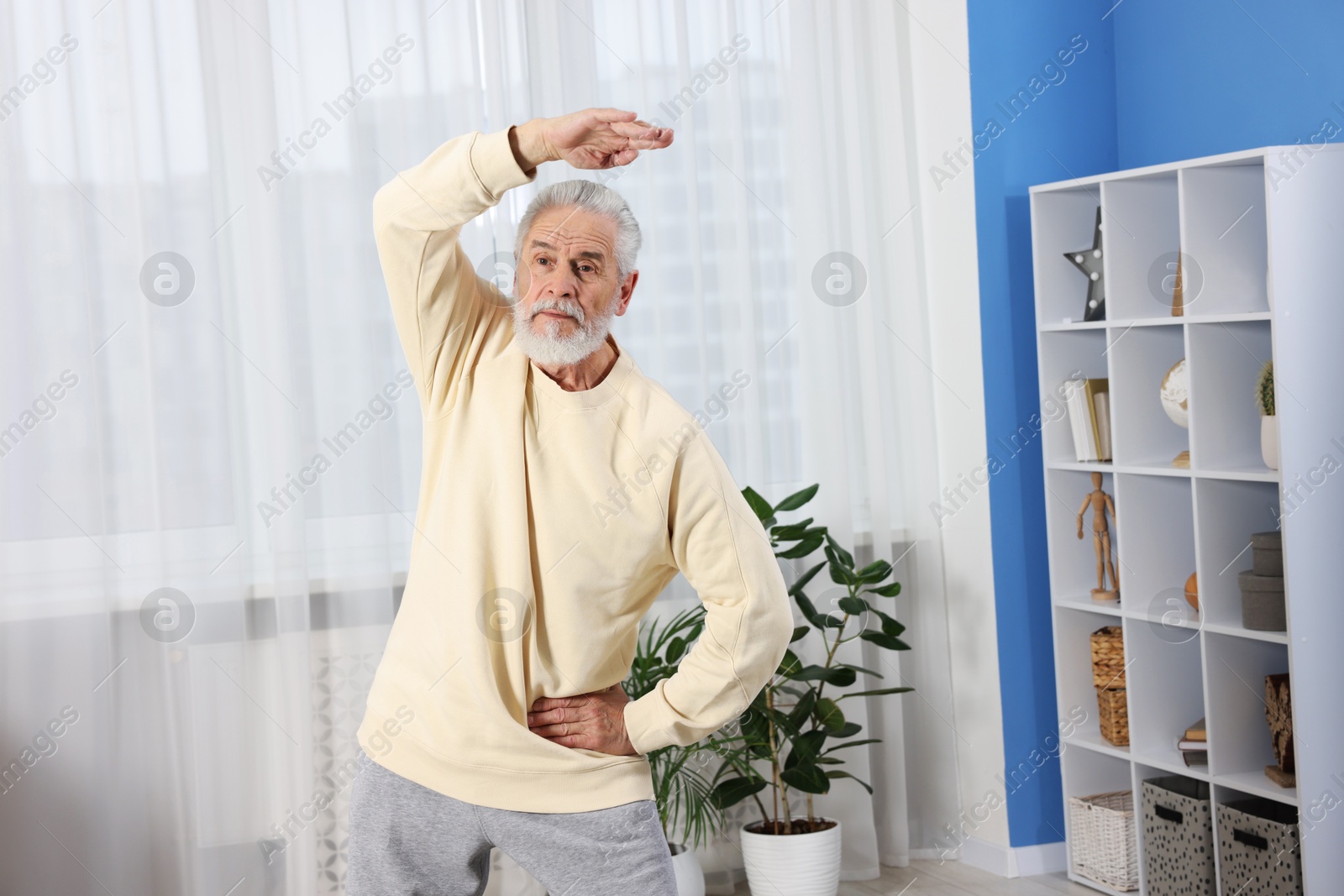 Photo of Elderly man exercising at home. Healthy leisure