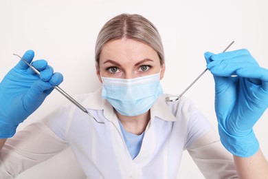 Photo of Professional dentist with tools on white background