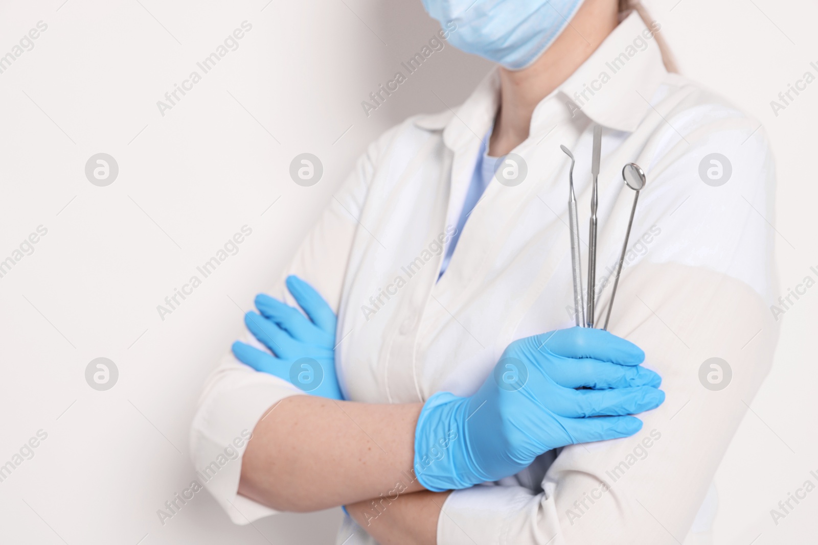 Photo of Professional dentist with tools on white background, closeup