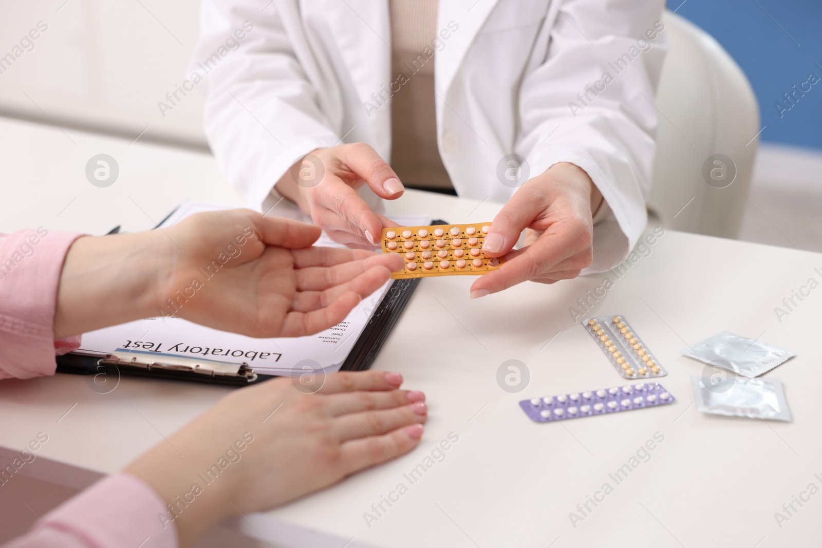 Photo of Gynecologist recommending contraceptive pills to woman in clinic, closeup