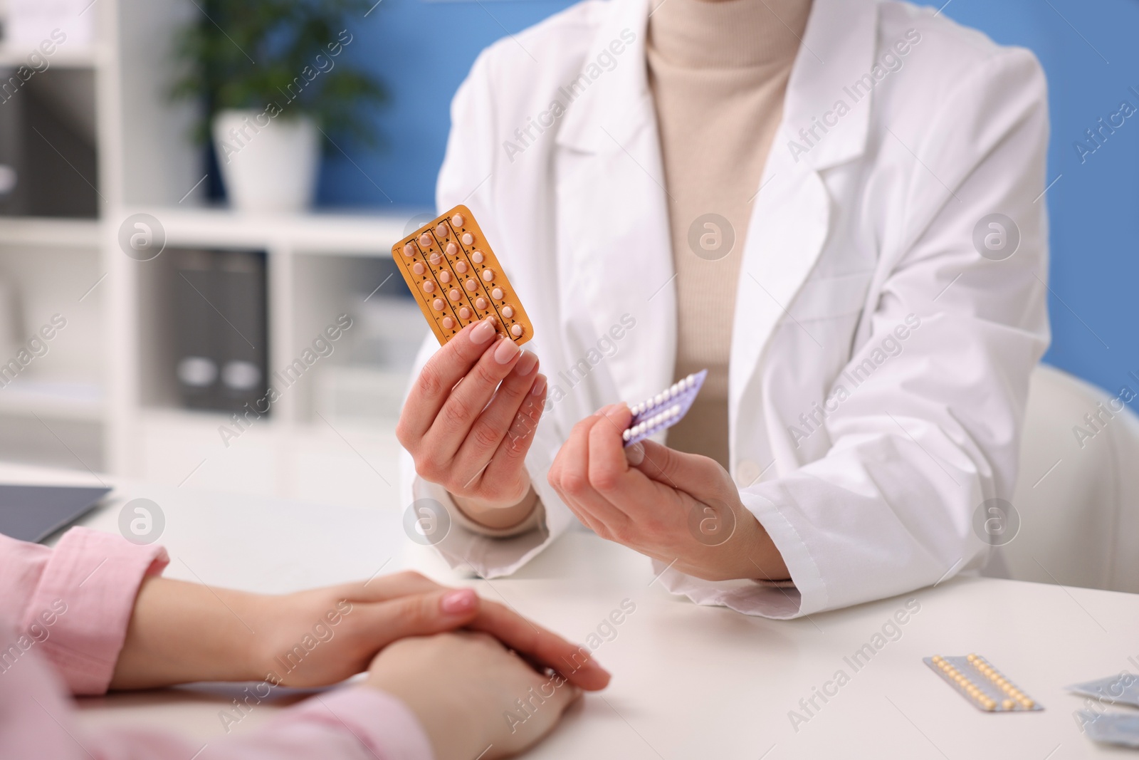 Photo of Gynecologist recommending contraceptive pills to woman in clinic, closeup