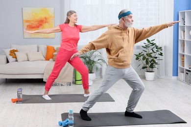 Photo of Elderly couple exercising at home. Healthy leisure