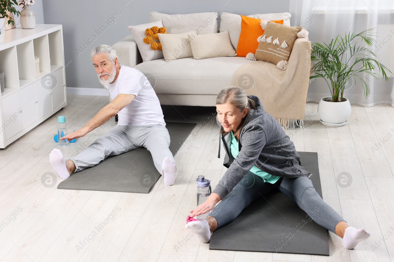 Photo of Elderly couple exercising at home. Healthy leisure