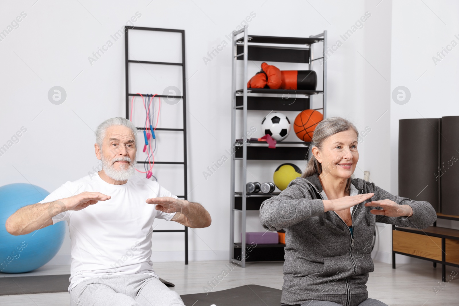 Photo of Elderly couple exercising at home. Healthy leisure