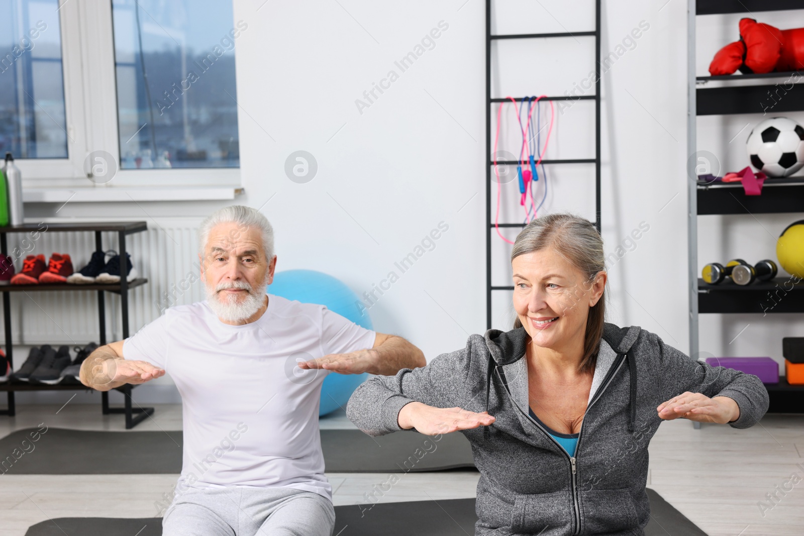 Photo of Elderly couple exercising at home. Healthy leisure