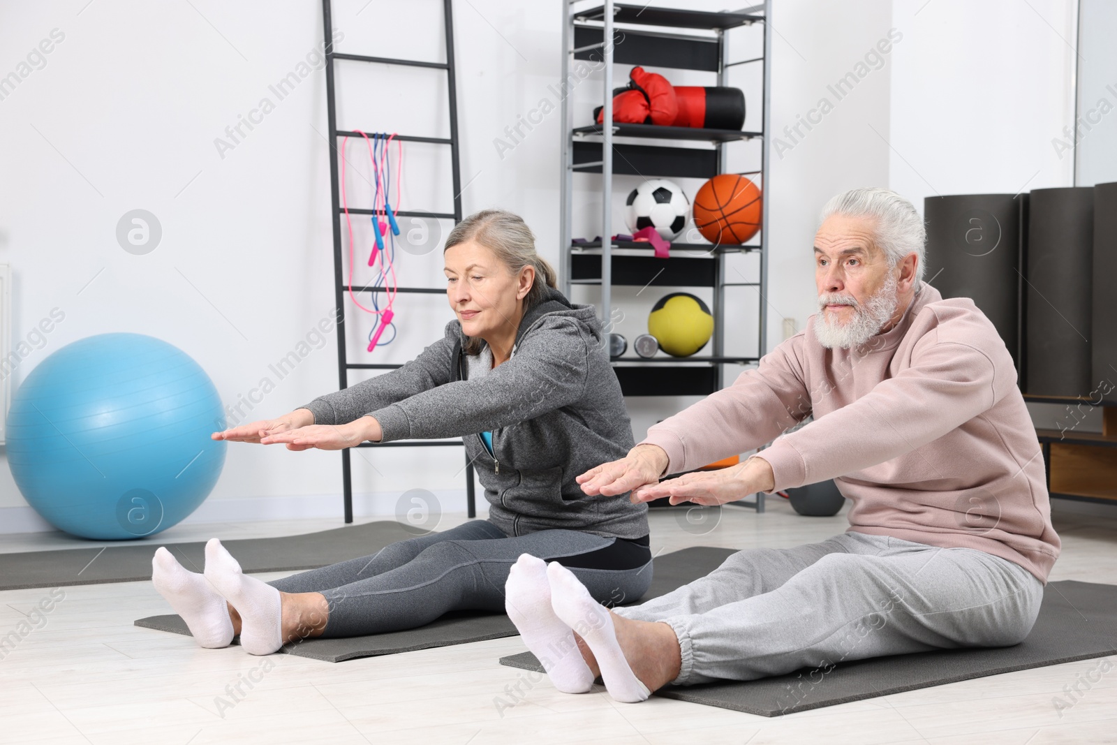 Photo of Elderly couple exercising at home. Healthy leisure