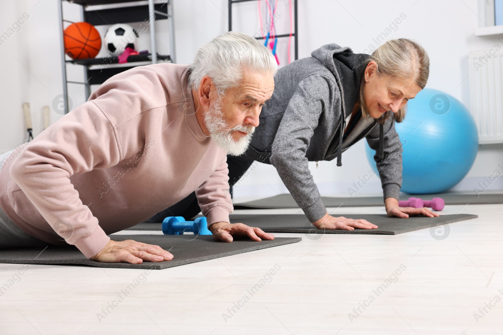 Photo of Elderly couple exercising at home. Healthy leisure