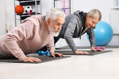 Elderly couple exercising at home. Healthy leisure