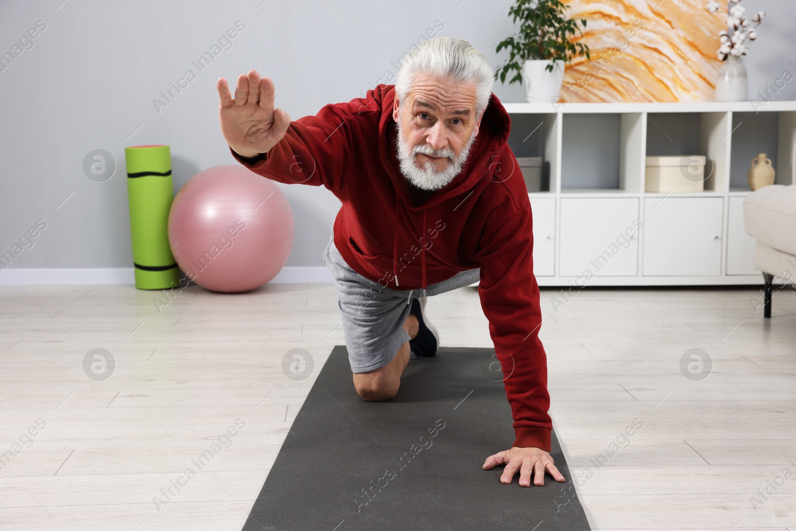 Photo of Elderly man exercising at home. Healthy leisure