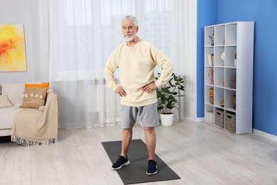 Photo of Elderly man exercising at home. Healthy leisure