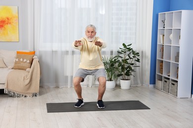 Photo of Elderly man exercising at home. Healthy leisure