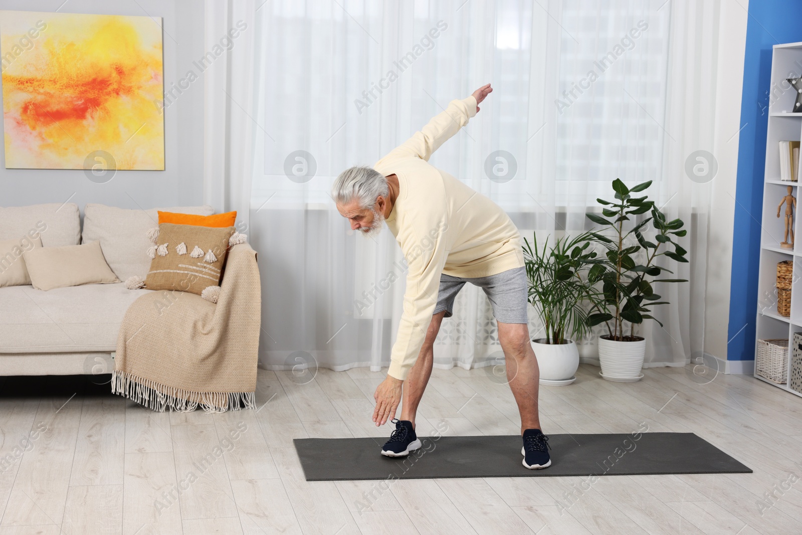 Photo of Elderly man exercising at home. Healthy leisure