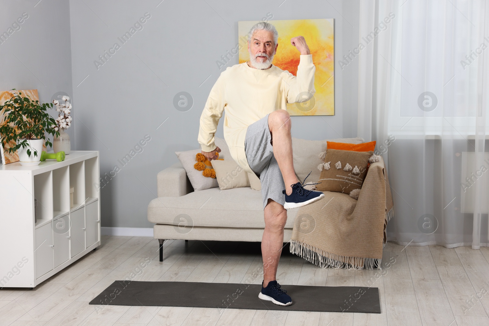 Photo of Elderly man exercising at home. Healthy leisure