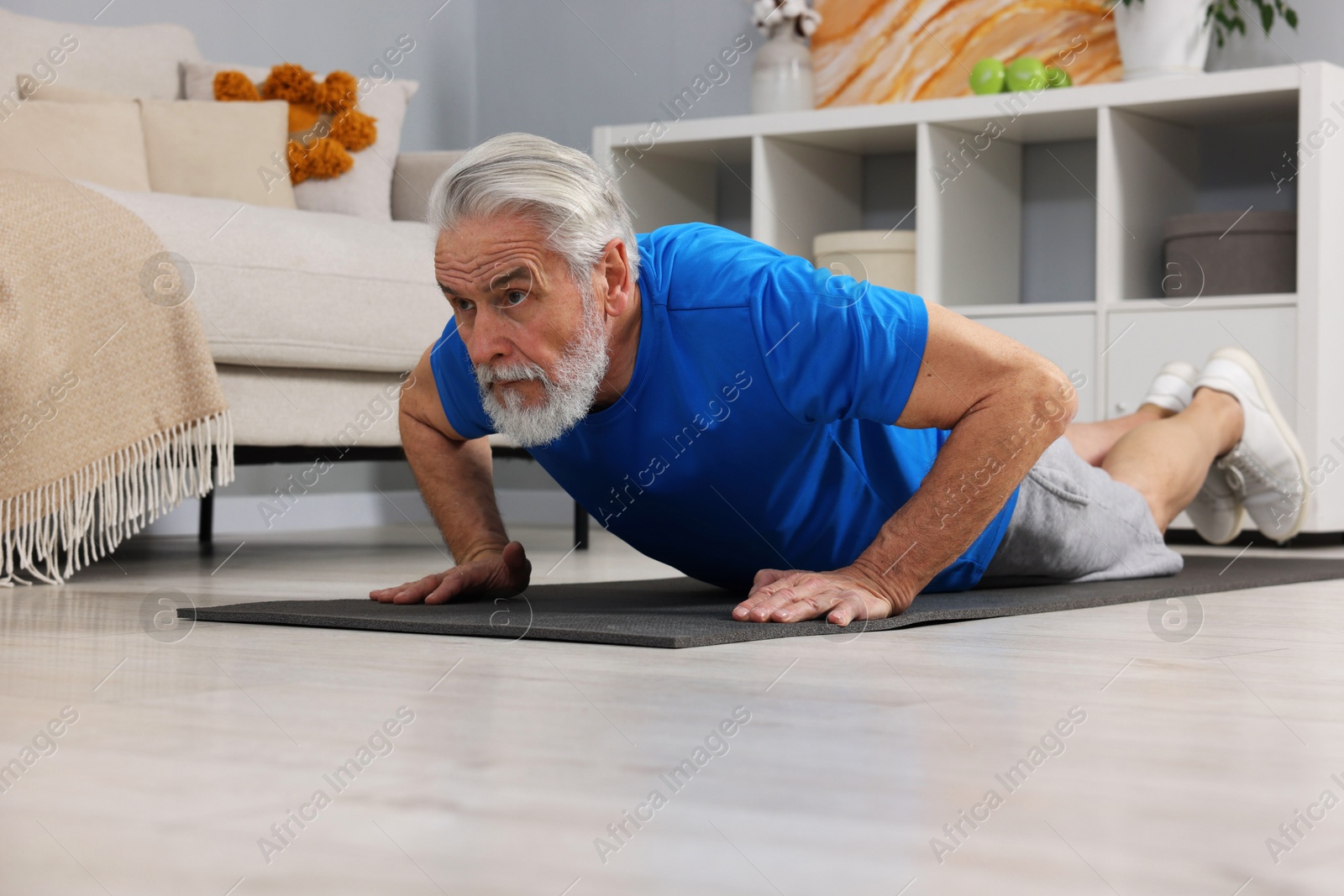 Photo of Elderly man exercising at home. Healthy leisure