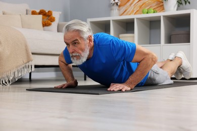 Elderly man exercising at home. Healthy leisure